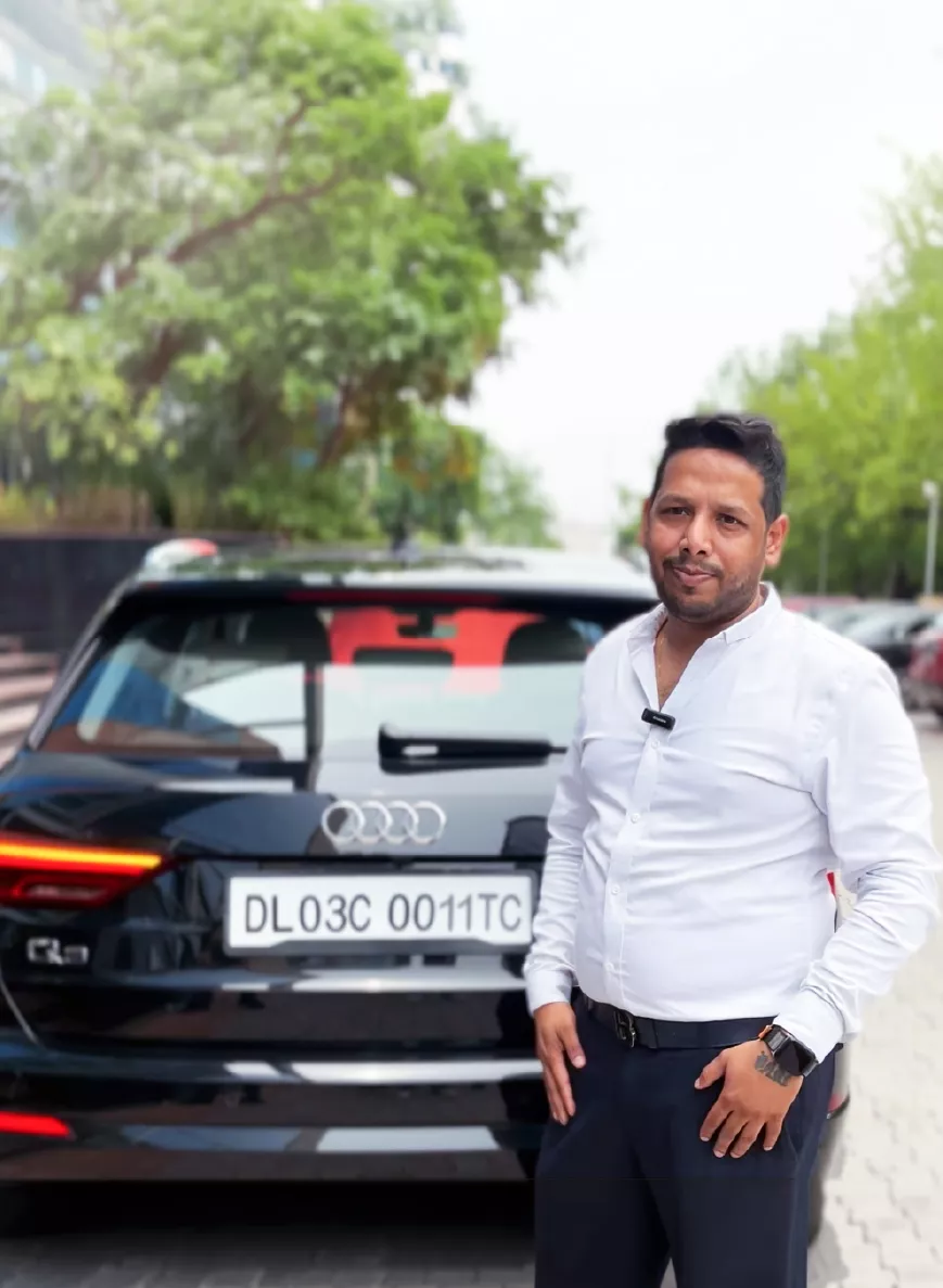 Employee posing with an Audi reward